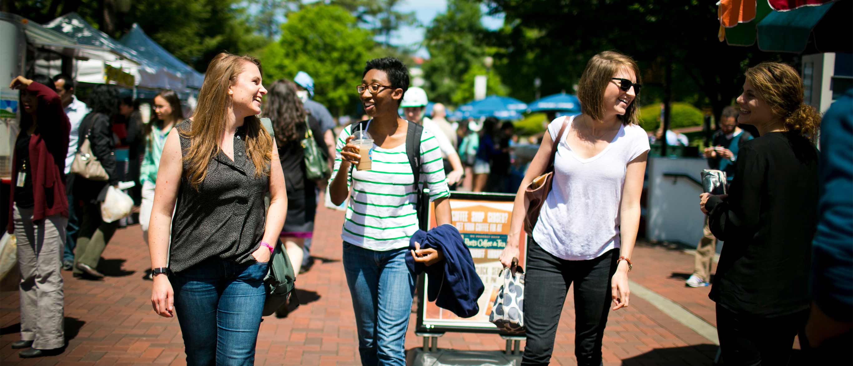 three women walking through the Emory farmers market