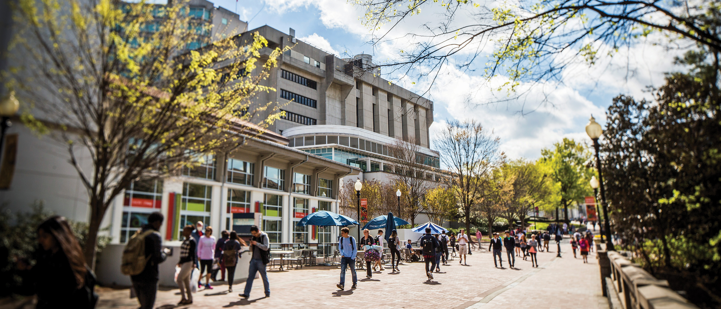 Students strolling along  interior Emory Atlanta campus in front of Cox Hall