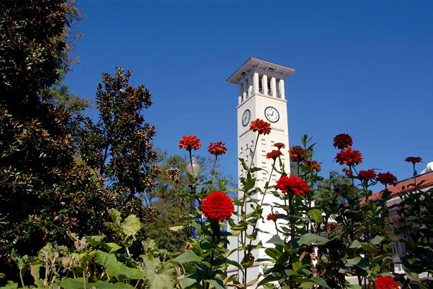 Cox Hall with red geraniums in the foreground