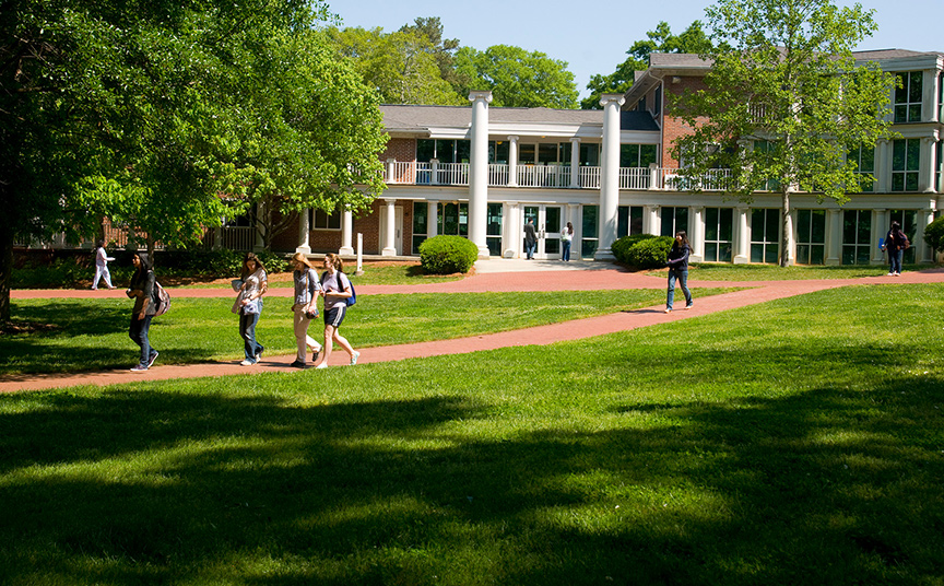 students walking across Oxford College campus in front of residence hall