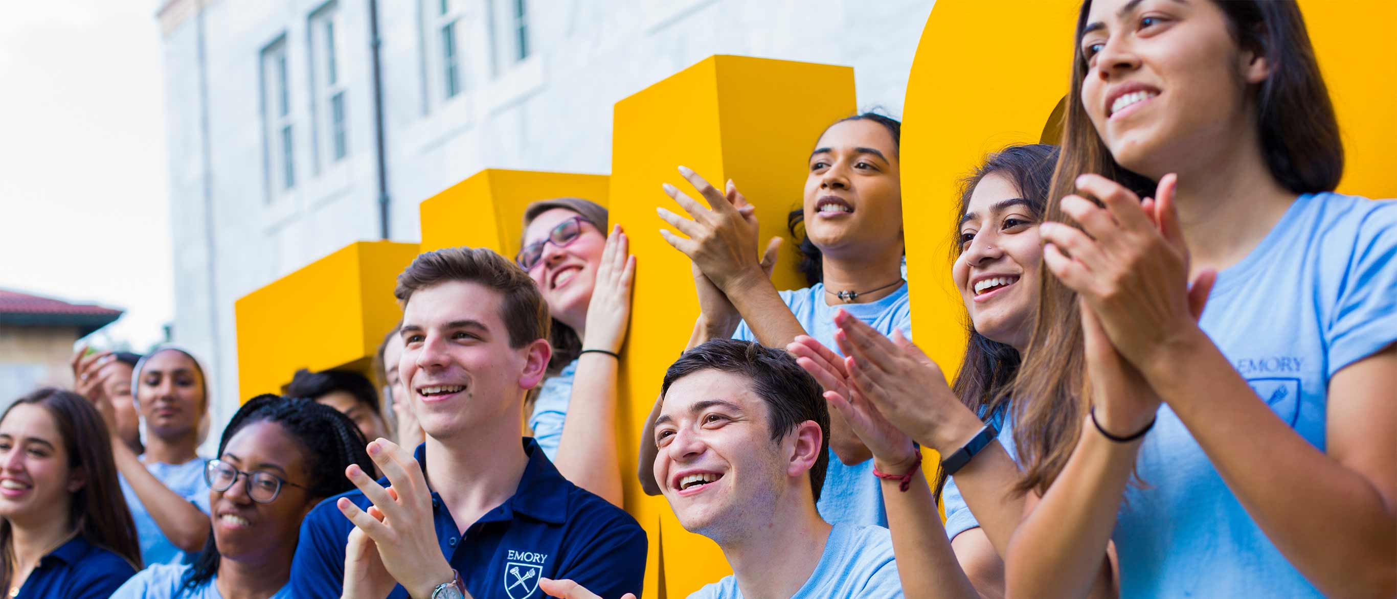 Orientation leaders in front of gold Emory sign